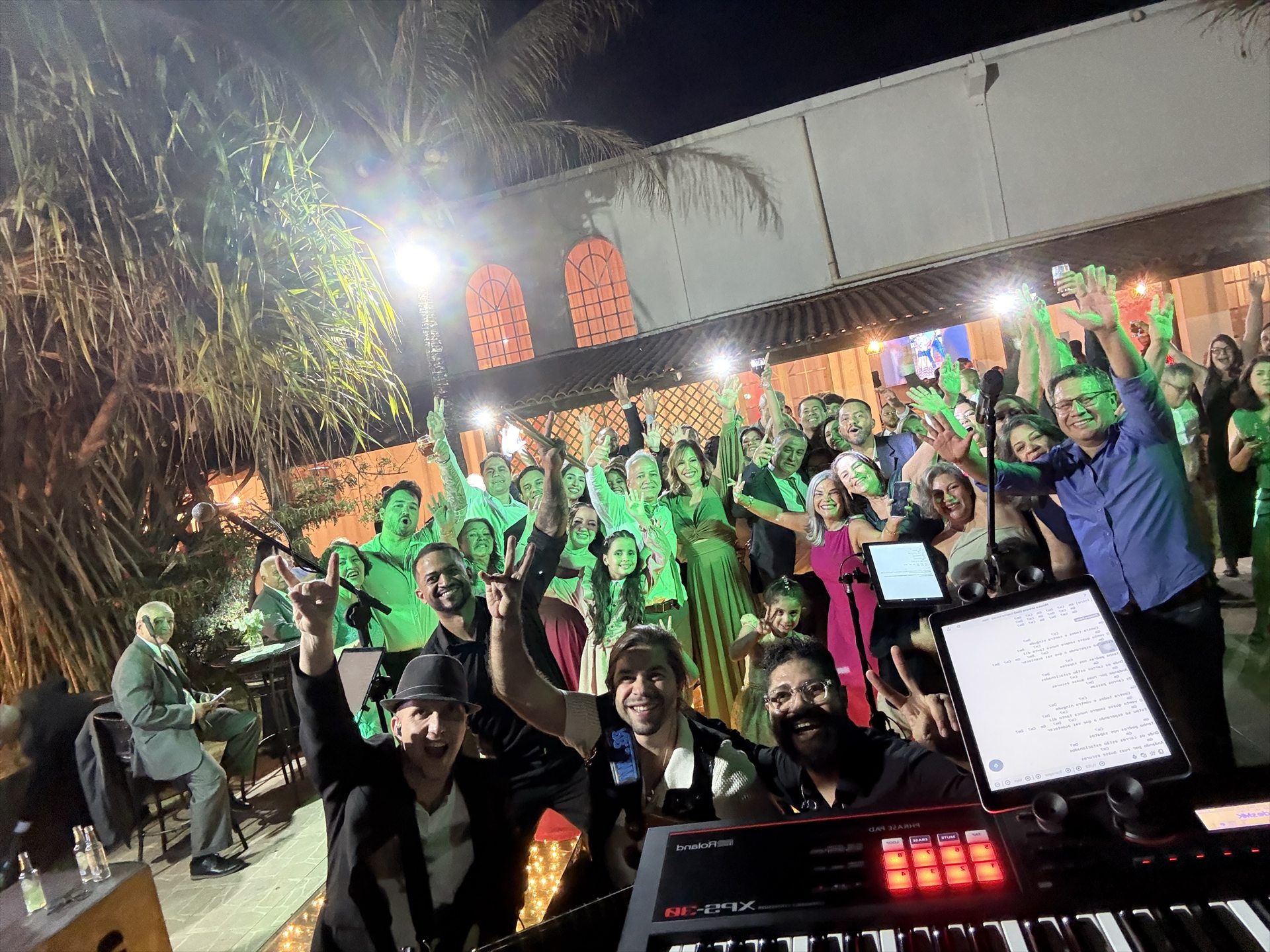 Banda em primeiro plano e convidados celebrando juntos em uma festa